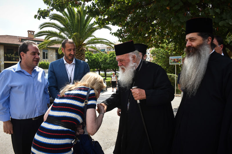 Η πρόεδρος του Ελπίδα σκύβει να φιλήσει το χέρι του Αρχιεπισκόπου