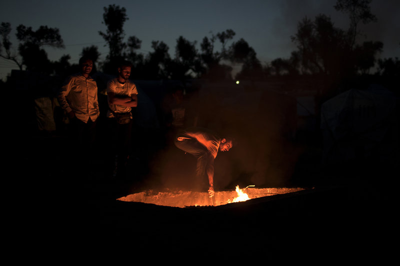 Πρόσφυγες καίνε σκουπίδια σε λάκο για να ζεσταθούν στον καταυλισμό της Μόρια (Φωτιογραφία: ΑΡ) 