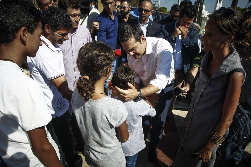Ο Αλέξης Τσίπρας χαιδεύει το κεφάλι ενός παιδιού που τον υποδέχθηκε- φωτογραφία eurokinissi
