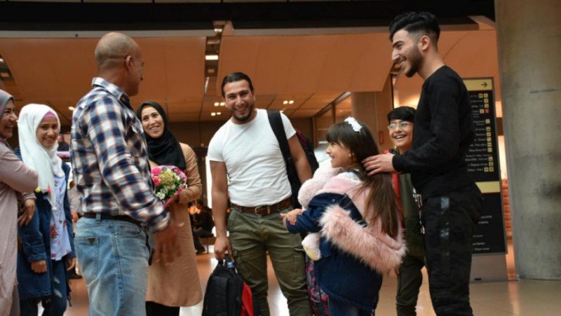 Ο Numeir (δεξιά) σμίγει επιτέλους και πάλι με την οικογένειά του στο αεροδρόμιο. Φωτογραφία: UNHCR/Chris Melzer)