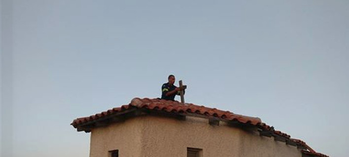 Πυροσβέστης τοποθετεί τον σταυρό σε καμένο εκκλησάκι στην Πεντέλη- Για να γαληνέψουν οι ψυχές