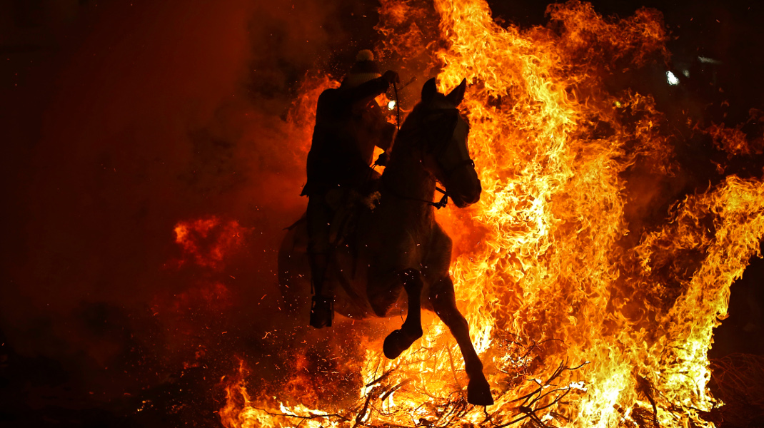 Αναβάτης και άλογο πηδούν φωτιές στη γιορτή του Αγίου Αντωνίου, όπως ορίζει το έθιμο σε χωριό της Ισπανίας -AP Photo/Francisco Seco