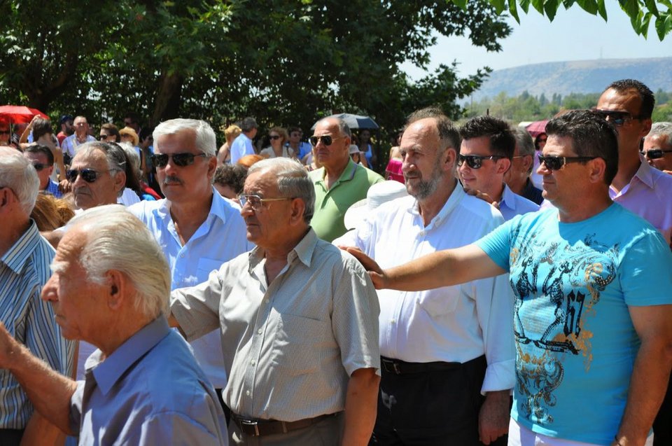 Ο ενας κρατά τον ωμο του άλλου και κάποιος κρατάει την εικόνα της Παναγίας στα χέρια
