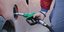 Υπάλληλος σε πρατήριο υγρών καυσίμων γεμίζει με βενζίνη το ρεζερβουάρ ΙΧ 
