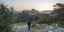 Γυναίκα κοιτάζει το ηλιοβασίλεμα στην Ακρόπολη από τον λόφο Φιλοπάππου