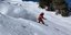 Άνδρας κάνει snowboard σε πλαγιά βουνού
