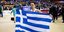 Ο Λευτέρης Πετρούνιας με την ελληνική σημαία /Φωτογραφία: Εurokinissi