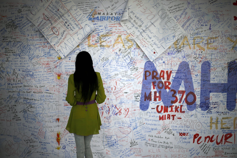 Συγγενής αγνοούμενου της πτήσης MH370 διαβάζει μηνύματα σε πίνακα ανακοινώσεων στο αεροδρόμιο της Κουάλα Λουμπούρ