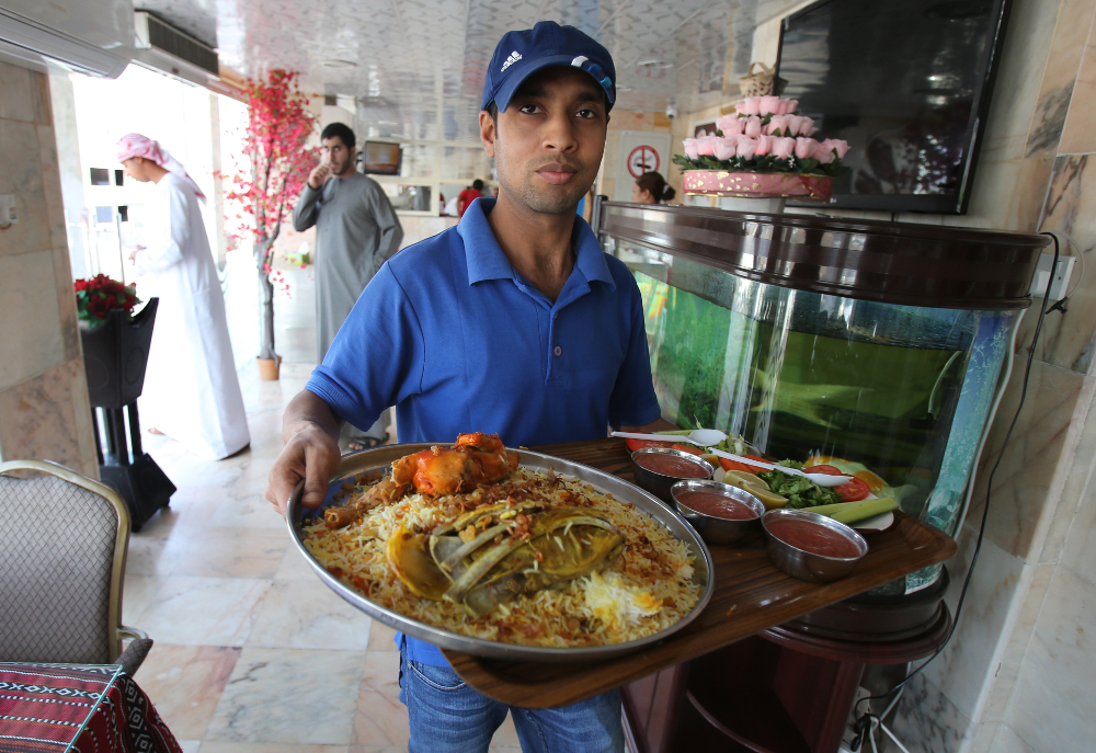Σερβιτόρος στο Ντουμπάι σερβίρει αρνί με ρύζι 