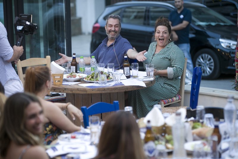 Η Βίκυ Σταυροπούλου και ο Χρήστος Χατζηπαναγιώτης χαμογελαστοί κάθονται σε τραπέζι