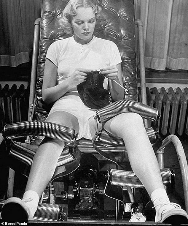 Μια γυναίκα φωτογραφίζεται χαλαρή, να δοκιμάζει ένα μηχάνημα απώλειας βάρους από σωλήνες ενώ πλέκει το 1940