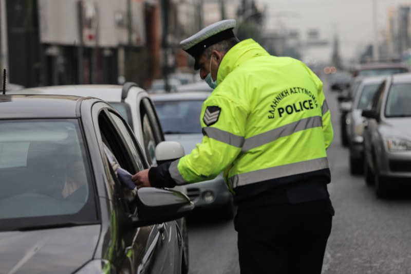 Αστυνομικός με γυμνά χέρια πιάνει τα έγγραφα πολίτη κατά τη διάρκεια του ελέγχου