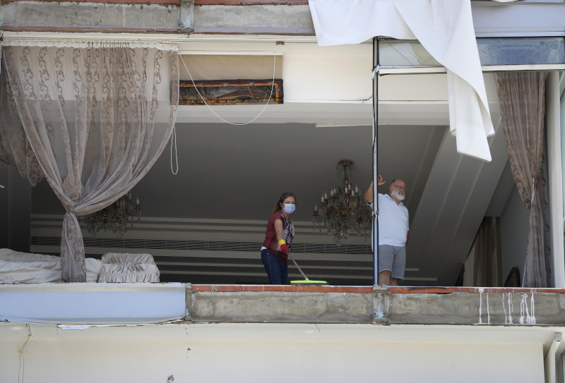Ανθρωποι στέκονται σε κατεστραμμένο σπίτι στη Βηρυτό