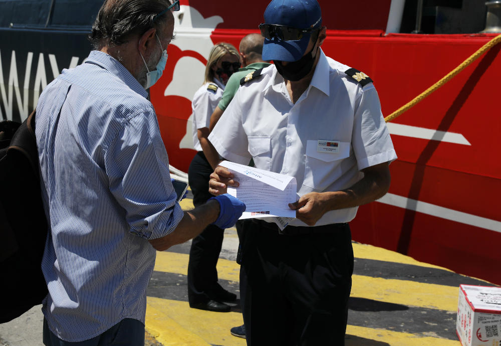 Άνδρας του Λιμενικού εξετάζει τα χαρτιά επιβατών στο λιμάνι