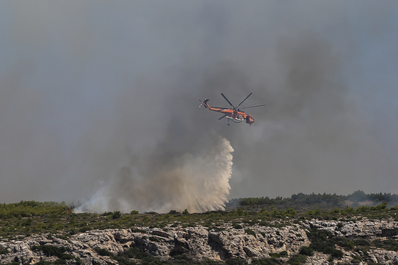 Ελικόπτερο ρίχνει νερό πάνω από φωτιά στο Λαύριο