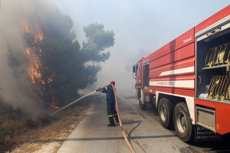 Πυροσβέστες επιχειρούν να κατασβέσουν τη φωτιά στη Ραφήνα