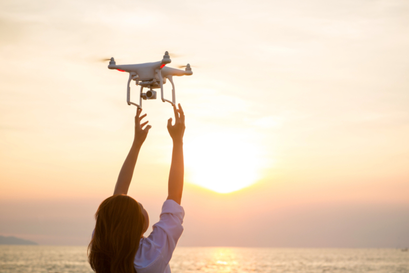Μία γυναίκα πιάνει ένα drone που είναι στον αέρα.