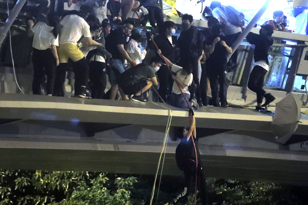 Με σχοινιά κατεβαίνουν οι διαδηλωτές από πεζογέφυρα προκειμένου να διαφύγουν της σύλληψης στο Χονγκ Κονγκ