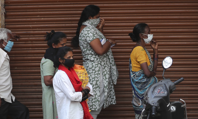 Γυναίκες και άνδρες με μάσκες στην Ινδία