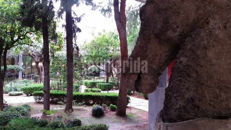 Αγαλμα αλόγου και ο κήπος ως φόντο