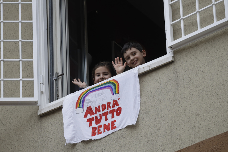 Παιδιά σε μπαλκόνι στην Ιταλία με πανό με ουράνιο τόξο