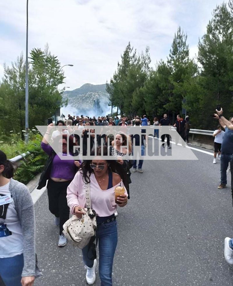 Συγκεντρωμένοι στη Μαλακάσα αποχωρούν καθώς στο βάθος είναι εμφανής σύννεφο καπνού από ρίψη χημικών