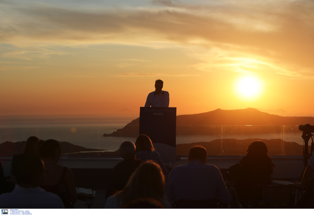 Εκπληκτική εικόνα με φόντο το ηλιοβασίλεμα της Σαντορίνη, με τον Κυριάκο Μητσοτάκη να μιλά στο βήμα