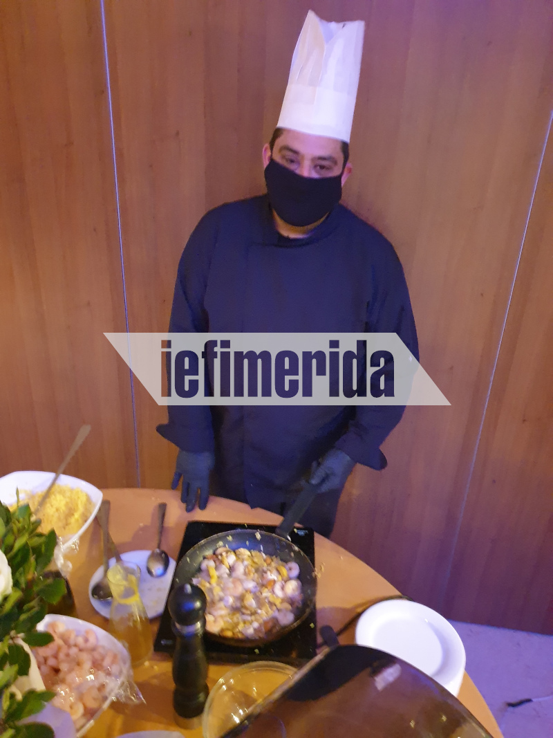 Ο σεφ ετοιμάζει παέγια με την απαραίτητη μάσκα