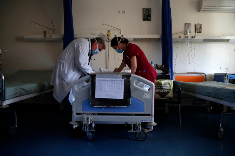 Η φοιτήτρια ιατρικής Αναστασία Γκιάλα, βοηθά τον γιατρό Βασίλη Μαραβίτσα να κάνει μια ελάχιστα επεμβατική επέμβαση σε έναν ασθενή στην παθολογική κλινική του νοσοκομείου Σωτηρία