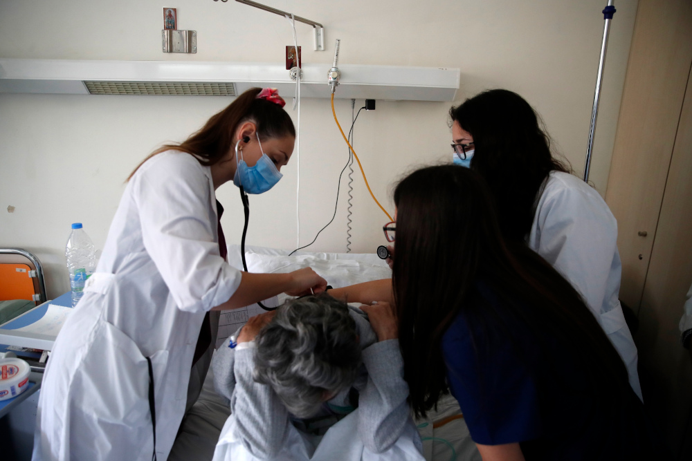 Οι φοιτήτριες ιατρικής Αφροδίτη Γεροδημοντάκη (αριστερά), Μιχαέλα Αλεξάνδρου (κέντρο) και Δήμητρα Σιάκαλλη (δεξιά) εξετάζουν μία ασθενή στην παθολογική κλινική του νοσοκομείου «Σωτηρία» 
