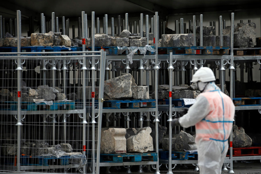 Εργάτες συγκεντρώνουν πέτρες και συντρίμμια από την Παναγία των Παρισίων όσο ξεκινούν δειλά - δειλά οι εργασίες αποκατάστασης