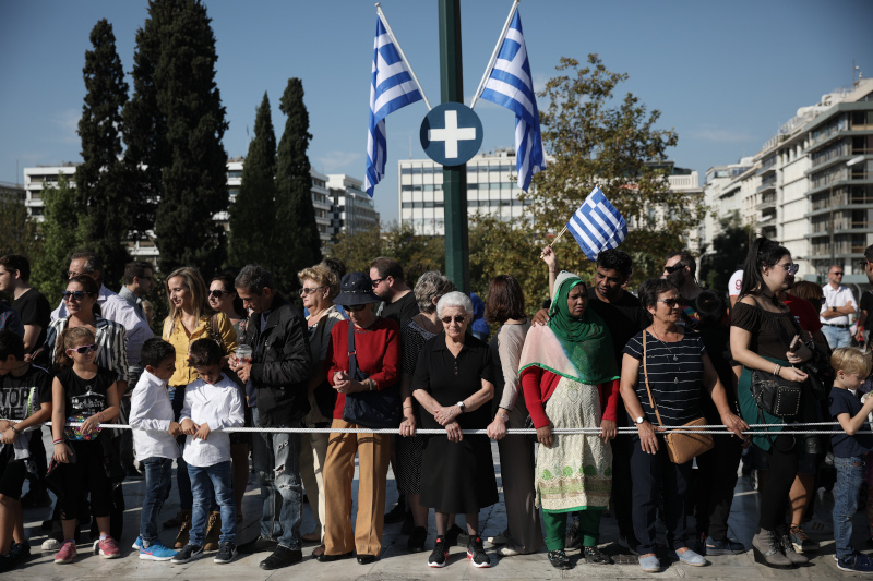 Πλήθος κόσμου συγκεντρώθηκε από νωρίς στην Πλατεία Συντάγματος στο κέντρο της Αθήνας προκειμένου να παρακολουθήσει την μαθητική παρέλαση.