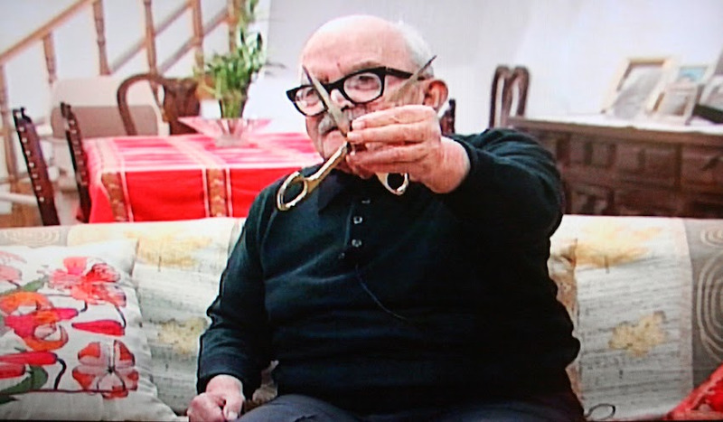 Ο συνταγματάρχης Λαδάς, ανήμπορος πια το 2008, ενώ επιδεικνύει το ψαλίδι, που του έστειλε ομοϊδεάτης του το 1968 