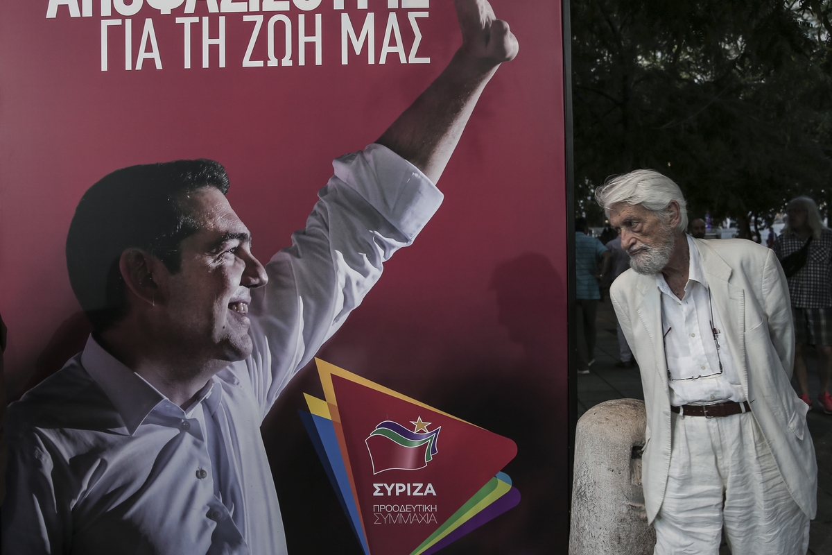 Ενας ηλικιωμένος κοιτάζει μια προεκλογική αφίσα του ΣΥΡΙΖΑ με τον Αλέξη Τσίπρα