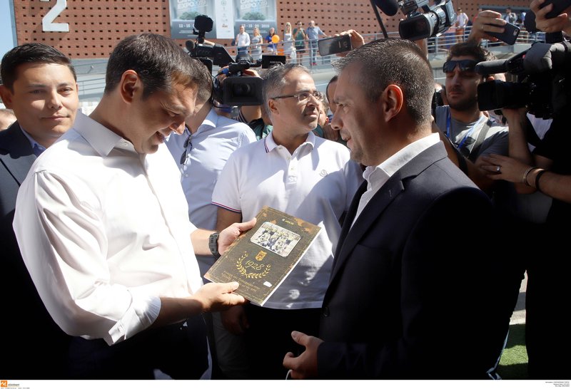 Ο Αλέξης Τσίπρας κρατά το βιβλίο με την ιστορία του Αρη που του έδωσαν στη ΔΕΘ