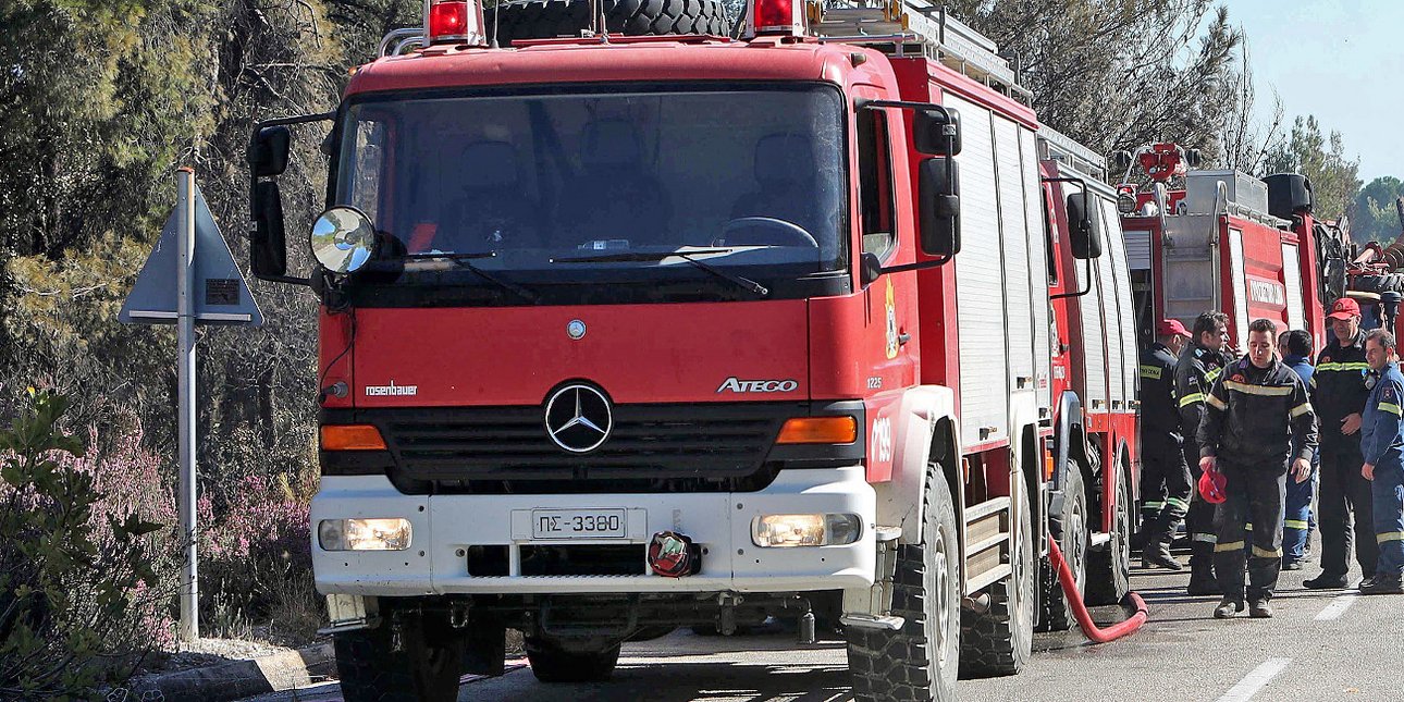 Πυροσβεστικό όχημα με πυροσβέστες στον δρόμο