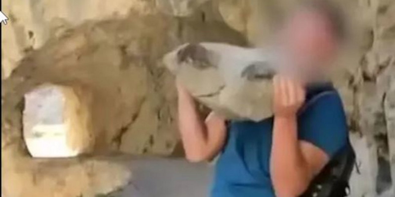 H στιγμή που ο τουρίστας ετοιμάζεται να πετάξει την πέτρα σε φαράγγι εθνικού πάρκου στην Ισπανία 