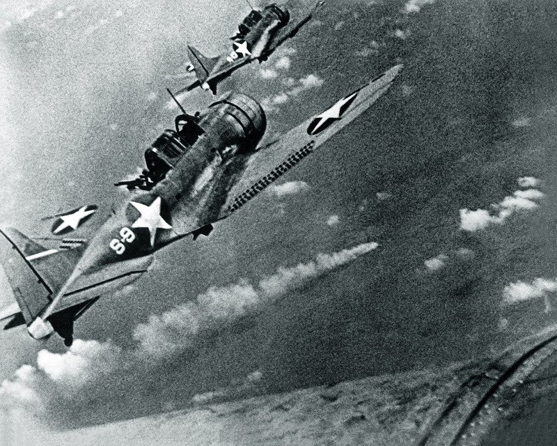 Αμερικανικά βομβαρδιστικά Douglas SBD-3 Dauntless ετοιμάζονται να επιτεθούν στο φλεγόμενο Ιαπωνικό πολεμικό πλοίο Mikuma στις 6 Ιουνίου 1942, στη ναυμαχία του Midway (Φωτογραφία: Wikipedia)