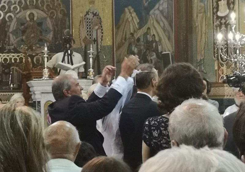 Ο Κώστας Καραμανλής την ώρα που αλλάζει τα στέφανα.