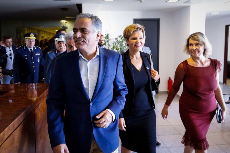 Διερευνητικά βλέμματα καθώς ο Πάνος Σκουρλέτης τις οδηγεί στην αίθουσα Τύπου του υπουργείου