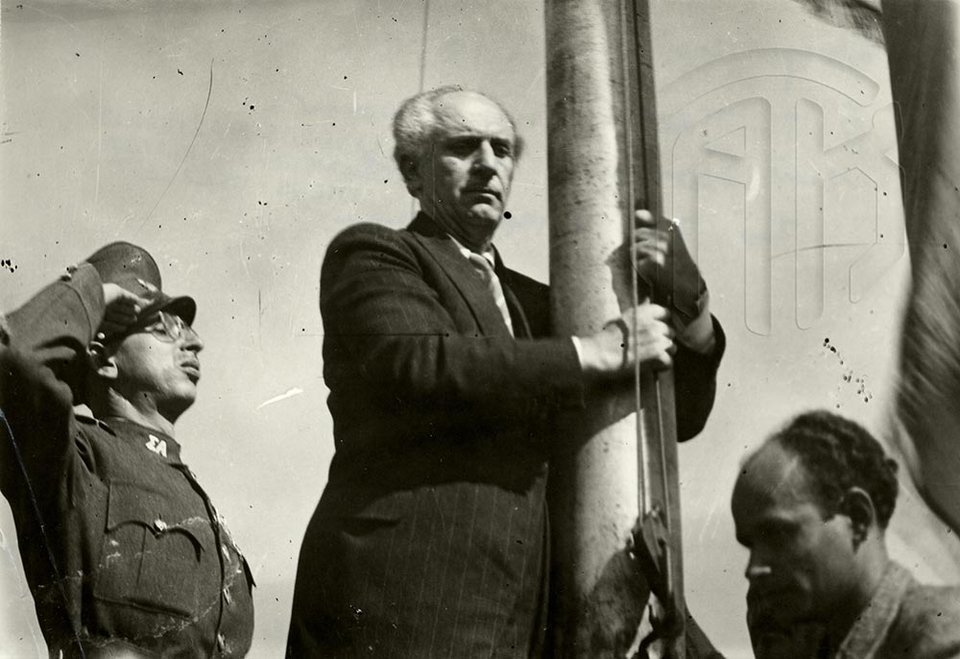 18 Οκτωβρίου 1944. Ο πρωθυπουργός Γεώργιος Παπανδρέου κατά την πρώτη ελεύθερη έπαρση της ελληνικής σημαίας στην Ακρόπολη, Γενικά Αρχεία του Κράτους – Κεντρική Υπηρεσία – Βασίλης Τσακιράκης