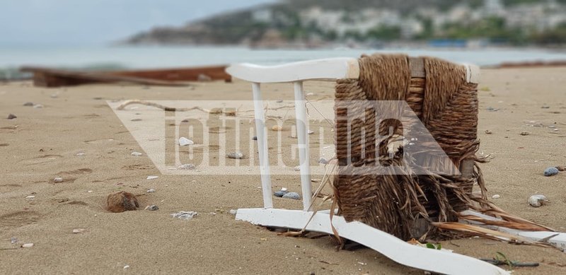 Μία καρέκλα διαλυμένη και πεσμένη στην άμμο