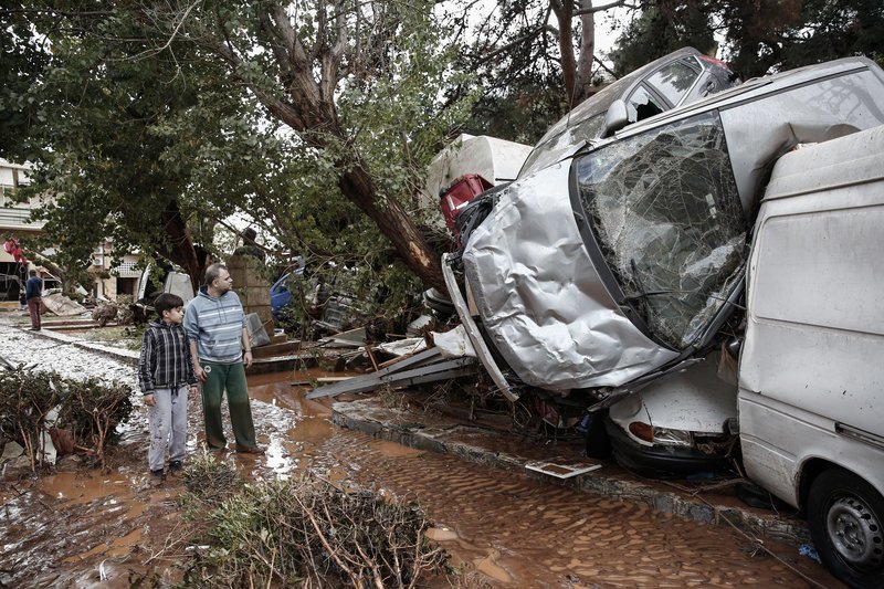 Το παιδάκι κοιτάζει σαστισμένο, μαζί με τον πατέρα του, το μέγεθος των ζημιών -Φωτογραφία: Eurokinissi