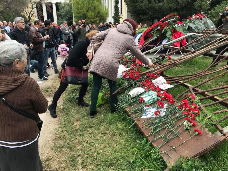Απλοί πολίτες αφήνουν το δικό τους λουλούδι στην Πύλη.