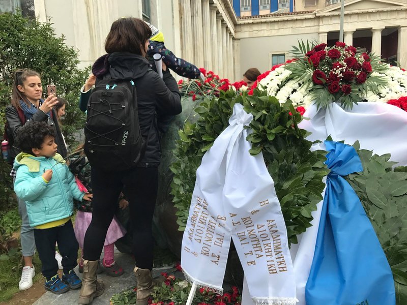 Γονείς με τα παιδιά τους άφησαν λουλούδια στο μνημείο και την πύλη.