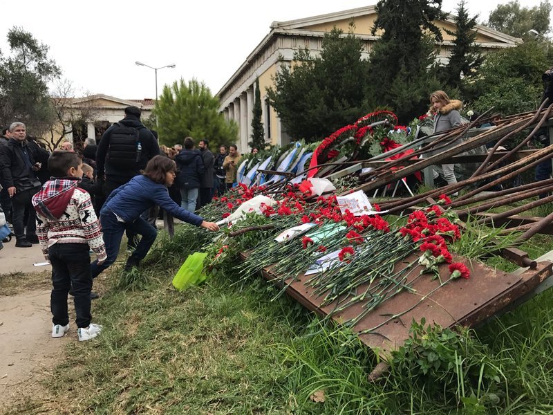 Παιδιά αφήνουν λοθλούδια στην Πύλη που είχε ρίξει το τανκ με την εισβολή του.