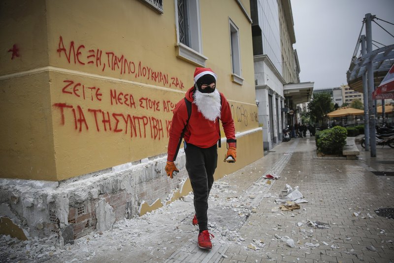 Διαδηλωτής ντυμένος Αγιος Βασίλης γράφει με σπρέϊ συνθήματα / Φωτογραφία: EUROKINISSI/ΣΤΕΛΙΟΣ ΜΙΣΙΝΑΣ
