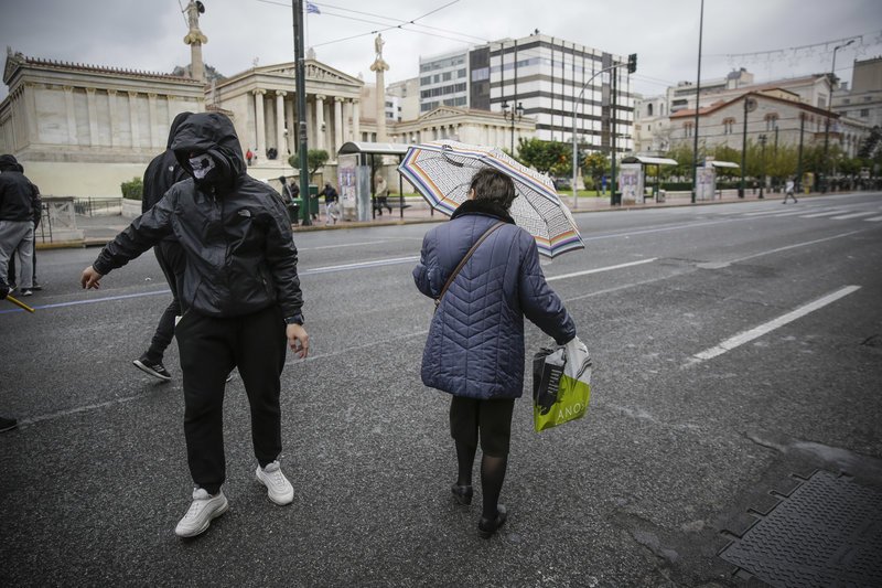 Ανάμεσα στους κουκουλοφόρους και μία άτυχη πολίτης / Φωτογραφία: EUROKINISSI/ΣΤΕΛΙΟΣ ΜΙΣΙΝΑΣ