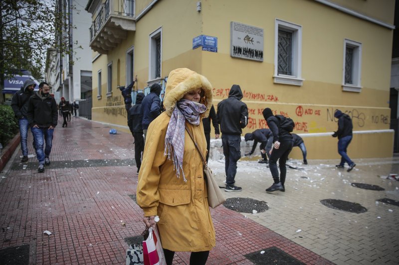 Οι αντιθέσεις στην Αθήνα. Μία πολίτης περπατά δίπλα στους καταστροφείς της πόλης / Φωτογραφία: EUROKINISSI/ΣΤΕΛΙΟΣ ΜΙΣΙΝΑΣ