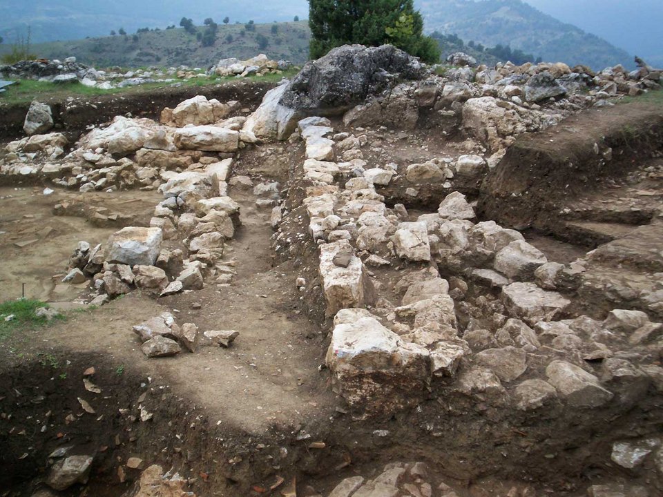 Στην αρχαία οχυρωμένη ακρόπολη στο Καστρί αναγνωρίστηκαν κατά τις προηγούμενες ανασκαφικές περιόδους τα οικοδομικά λείψανα του πετρόχτιστου άστυλου ναού, μιας δωρικής στοάς και ενός ακόμη μεγάλου οικοδομήματος, καθώς και τμημάτων της οχύρωσης με κυριότερο στοιχείο τη Δυτική Πύλη, στην περιοχή πίσω από το ναό.